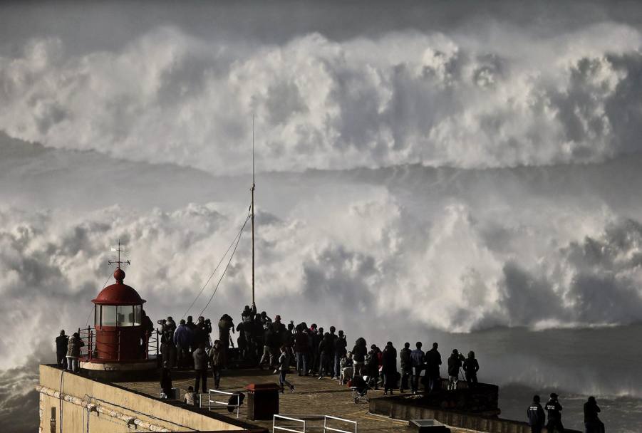 Una folla di curiosi assiste all&#39;impareggiabile spettacolo delle onde giganti sulle coste di Nazare, in Portogallo